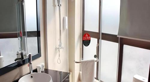 une salle de bain avec une douche avec un lavabo et un miroir dans l'établissement GreenTree Inn Taiyuan Xinghua Street, à Taiyuan