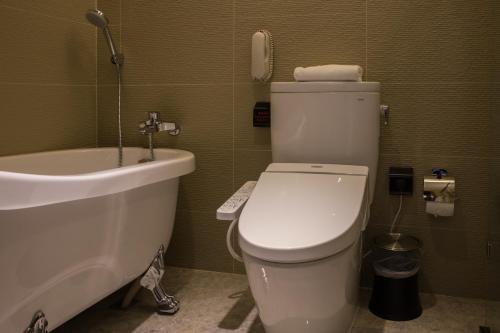 a bathroom with a toilet and a sink and a phone at Hotel In in Pingzhen