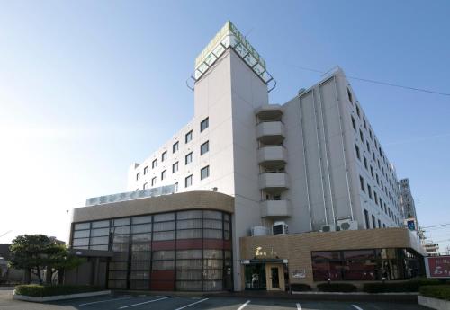 a white building with a clock on top of it at Ise City Hotel in Ise
