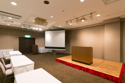 a conference room with a podium and a screen at Ise City Hotel in Ise