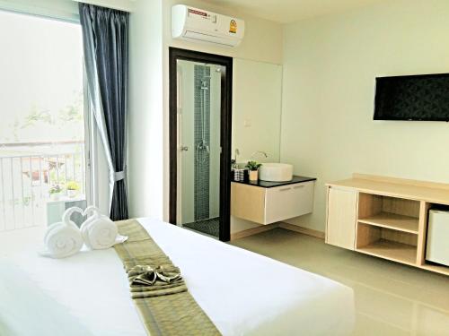 a hotel room with a bed and a television at The Wings Boutique Hotels Krabi Ko Lanta in Ko Lanta