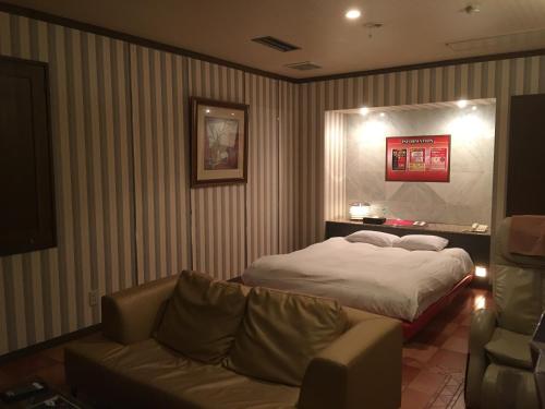 a hotel room with a bed and a couch at Hotel Fantacy (Adult Only) in Hamamatsu
