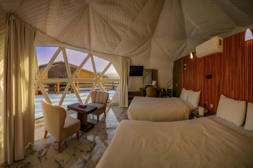 a hotel room with two beds and a large window at The Rock Camp Petra in Wadi Musa
