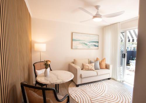 a living room with a couch and a table at Jasmine Hideaway Guesthouse Near SCUH Hospital in Kawana Waters