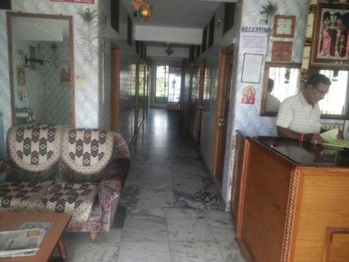 a man standing at a counter in a room at MSR Lodge in Tirupati