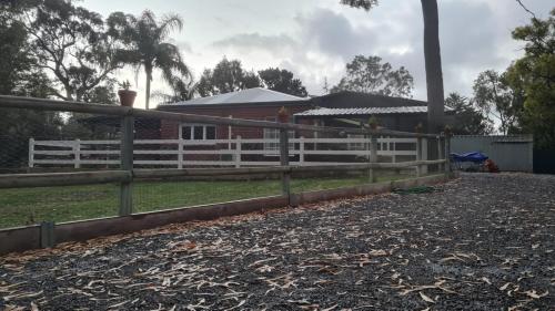 una valla blanca delante de una casa en R&R Roo & Rest, en Singleton