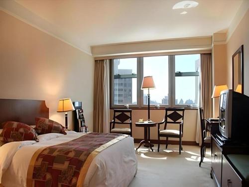 une chambre d'hôtel avec un lit, un bureau et une télévision dans l'établissement Fujian Hotel, à Pékin