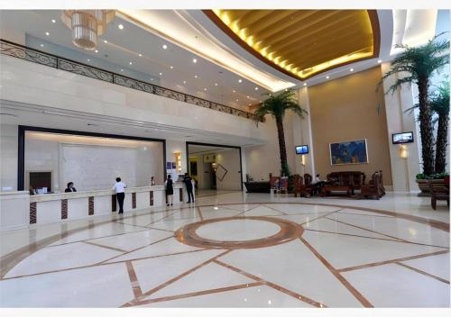 un hall d'entrée avec des gens debout dans un bâtiment dans l'établissement Borrman Hotel Dongguan Changping Avenue, à Dongguan