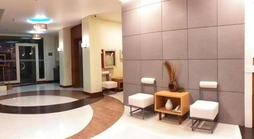 a lobby with white chairs and a wall at Hotel Camila 2 in Dipolog