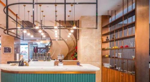 a bar in a restaurant with a chandelier at Hubei Poly Hotel in Wuhan