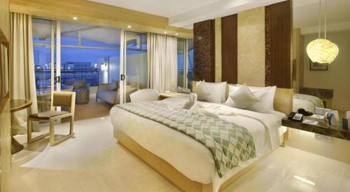 een slaapkamer met een groot bed en een woonkamer bij The Rinra in Tanjungbunga