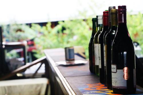 four bottles of wine sitting on a wooden table at Hotel Esplanada in Dili