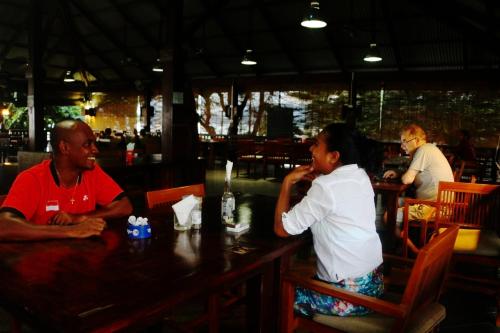 a woman sitting at a table in a restaurant at Hotel Esplanada in Dili