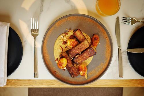 een bord eten met spek en aardappelen op een tafel bij The Max Hotel Sandton in Johannesburg