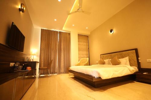 Un dormitorio con una cama y un televisor. en INSPIRE Hotel, en Kammasandra