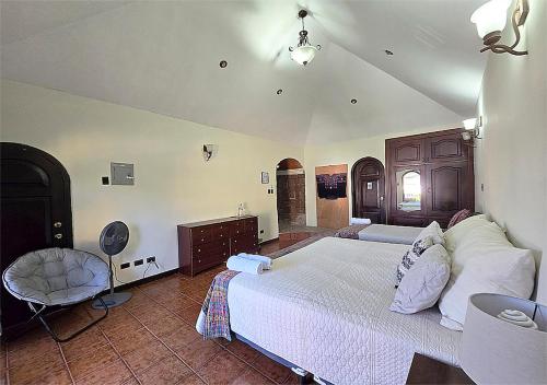 um quarto com uma cama grande e uma cadeira em A 3 minutos del aeropuerto em Estación Pamplona