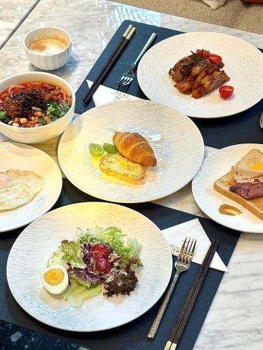 einen Tisch mit weißen Tellern. in der Unterkunft Novotel Kunming Yunjin in Kunming