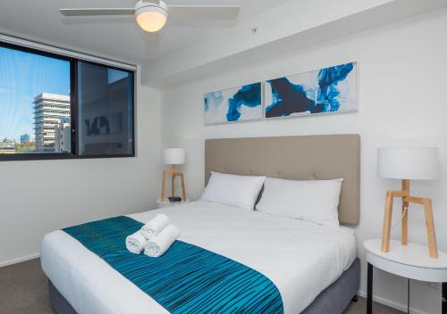 a bedroom with a bed and a large window at Annexe Apartments in Brisbane