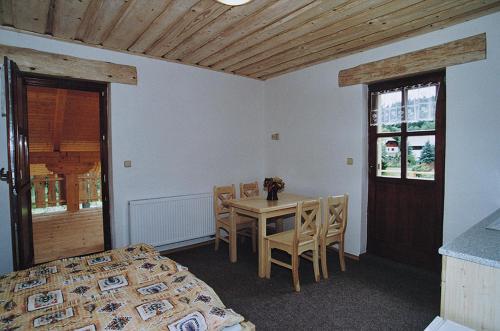 a bedroom with a table and a bed and a table and chairs at Pension Klose in Kubova Huť