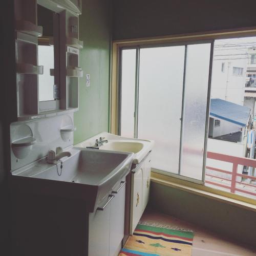 a bathroom with a sink and a large window at Guest House & Cafe Ohana in Imabari