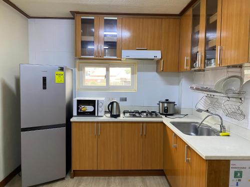 a kitchen with a white refrigerator and a sink at Bang-kito City Central Suites in Baguio