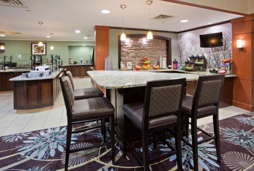 a large kitchen with a large island with bar chairs at Staybridge Suites Minneapolis-Bloomington by IHG in Bloomington