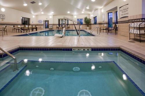 a pool in a hotel with tables and chairs at Staybridge Suites Minneapolis-Bloomington by IHG in Bloomington