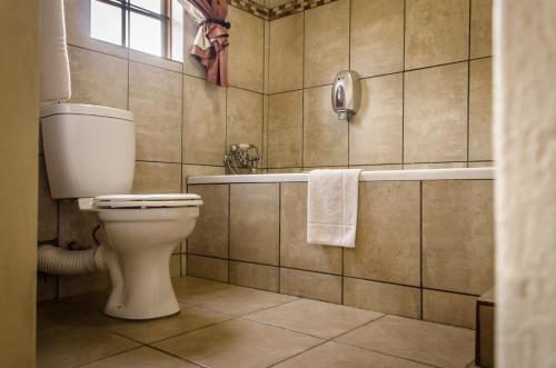 a bathroom with a toilet and a bath tub at Nelspruit Lodge in Nelspruit