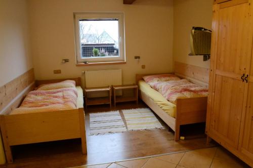 two beds in a small room with a window at Apartments Ve Dvoře in Mosty u Jablunkova