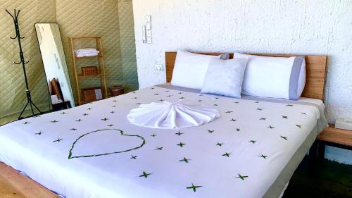 a bed with a white comforter with stars on it at Grand canyon domes Jabal shams in Sa‘ab Banī Khamīs