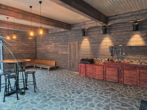 una cucina con un bancone, un tavolo e delle sedie di La Canton ad Adunaţi