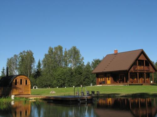 a large wooden cabin next to a lake at Väike-Pärna Holiday Home in Otepää
