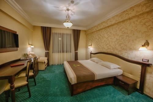 a hotel room with a bed and a desk at Magus Hotel in Baia Mare