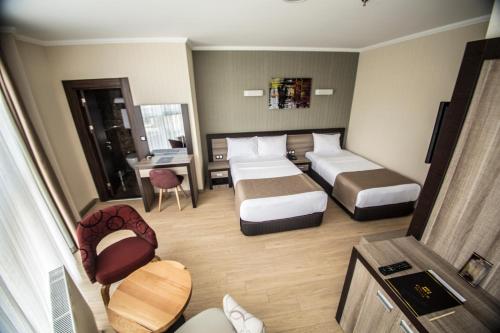 ein Hotelzimmer mit zwei Betten und einem Schreibtisch in der Unterkunft The Corner Hotel in Sincan