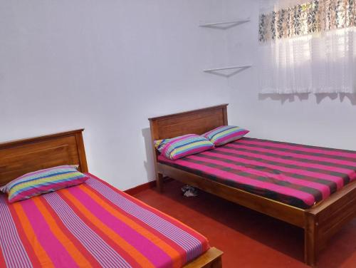 two twin beds in a room with at Villa Aavanthana in Ambalangoda