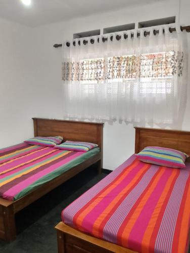 two beds sitting next to each other in a room at Villa Aavanthana in Ambalangoda