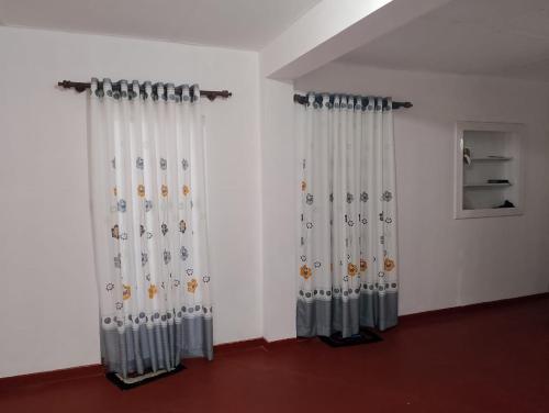 Una habitación con cortinas blancas con representaciones de mariposas. en Villa Aavanthana, en Ambalangoda