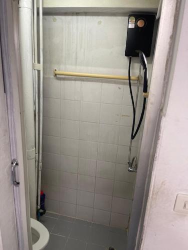 y baño con ducha, aseo y teléfono. en รัตนากร แมนชั่น, en Bang Su