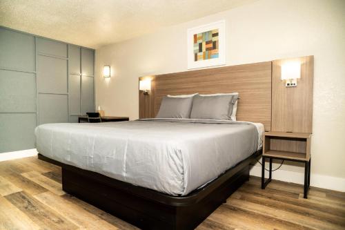 a bedroom with a large bed and two tables at Rodeway Inn Near Ybor City - Casino in Tampa