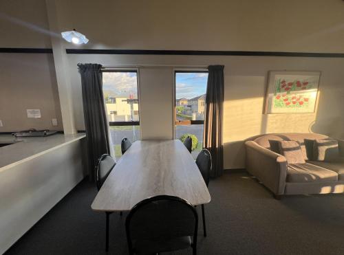 a room with a table and a couch and a bed at Mountain View Motel in Taupo