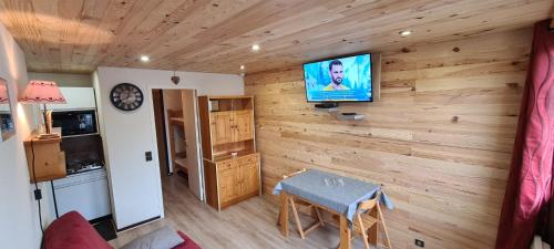 a room with a wooden wall with a television on it at Le Bois Joli en Chartreuse in Saint-Pierre-de-Chartreuse
