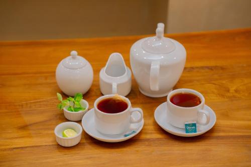 - une table avec deux tasses de thé et une théière dans l'établissement Emerald Resort Hikkaduwa, à Hikkaduwa