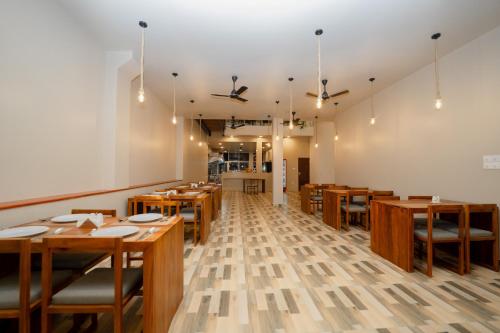 une salle à manger avec des tables et des chaises en bois dans l'établissement Emerald Resort Hikkaduwa, à Hikkaduwa