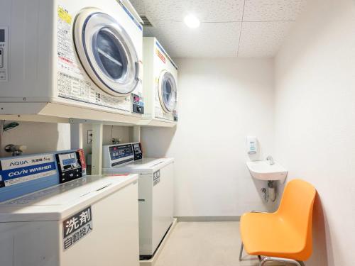 a hospital room with a washing machine and a orange chair at Comfort Inn Toyokawa Inter in Toyokawa