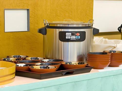 a table topped with bowls and a food processor at Hotel Abest Aomori in Aomori