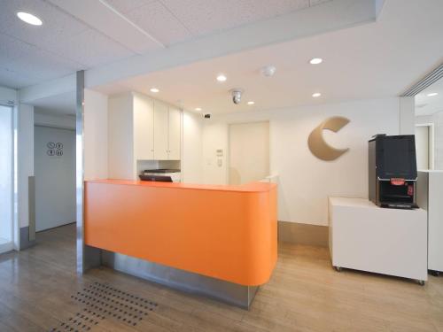 an office with an orange counter and a tv in a room at Comfort Inn Kumamoto Miyukifueda in Kumamoto