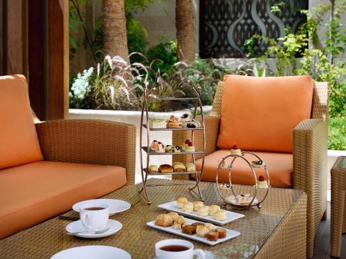 a table with two chairs and a tray of pastries at Voco - Riyadh by IHG in Riyadh