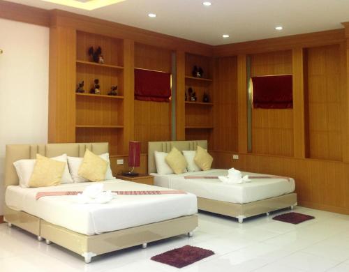two beds sitting in a room with shelves at Parada Place in Khon Kaen