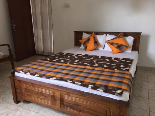 a bed with orange and blue pillows on it at Hanthana Jungle View Holiday Home in Kandy