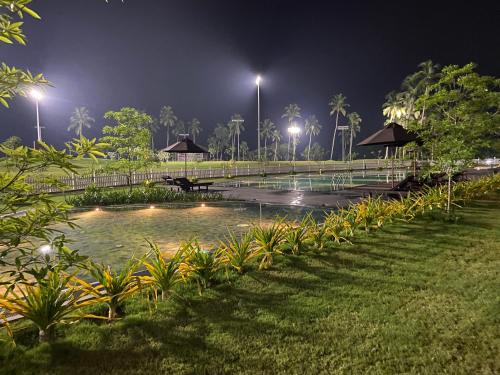 a pond with lights in a park at night at The Golfside Luxe in Gonapola